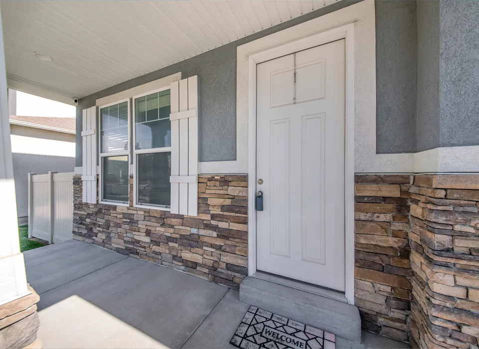 Stone veneer exterior cladding beside an entry door